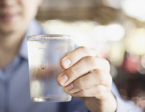 Frisches kaltes reines wasser des manngetranks im glas